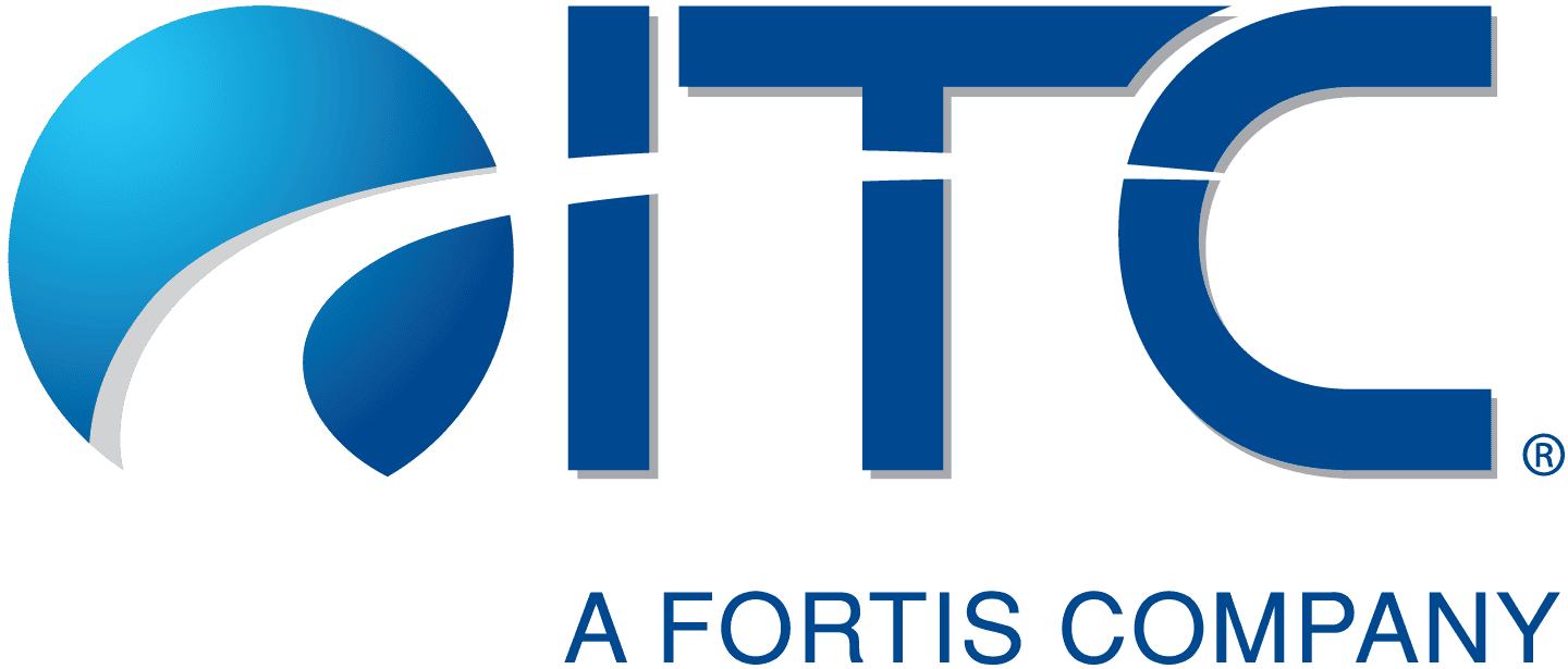 ITC Holdings representative presenting during a community program event, standing beside a display board with branding and informational materials.