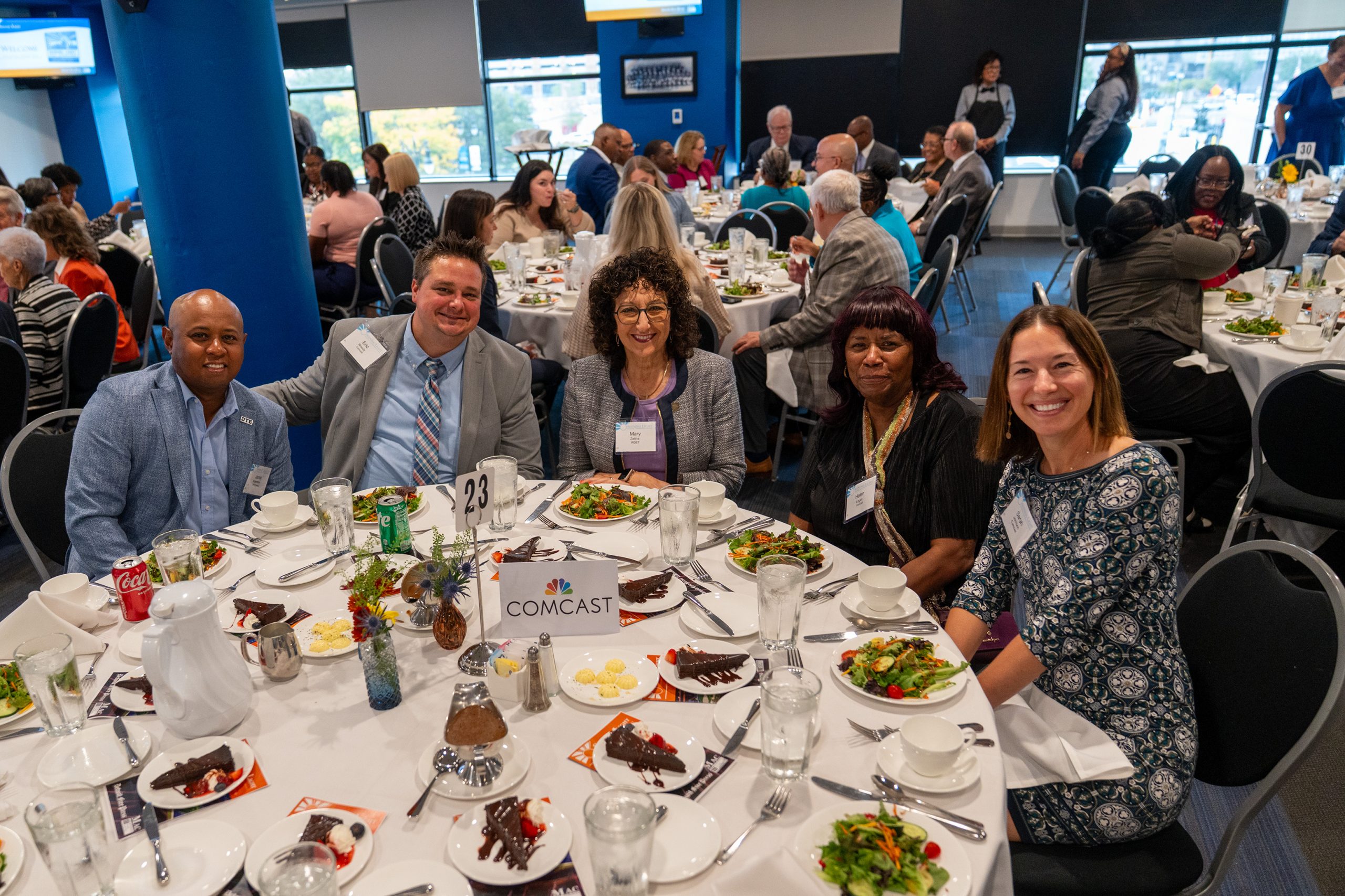 Award ceremony celebrating excellence in community service at the Shining Light Awards. Diverse guests enjoy a formal event with decorated tables, delicious food, and networking opportunities.