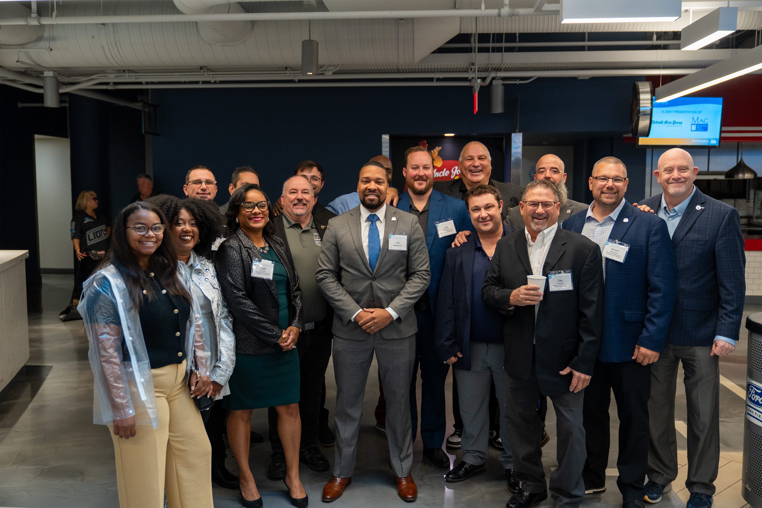 Celebrating diversity and leadership at the Shining Light Awards, showing a group of professionals in business attire posing together in a modern event space to honor community excellence.