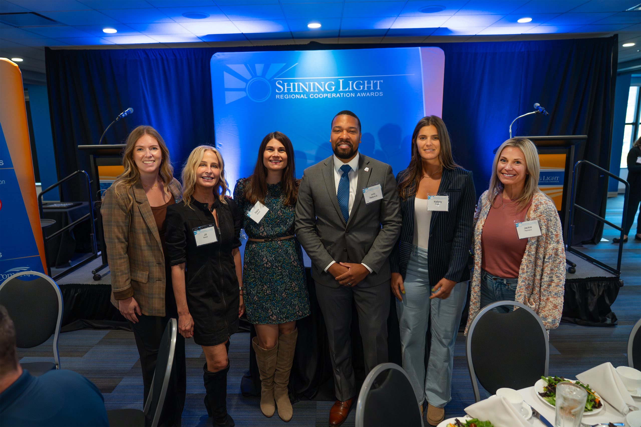 Diversity of professionals celebrating at the Shining Light Regional Cooperation Awards ceremony, showcasing recognition in regional collaboration and community achievement.