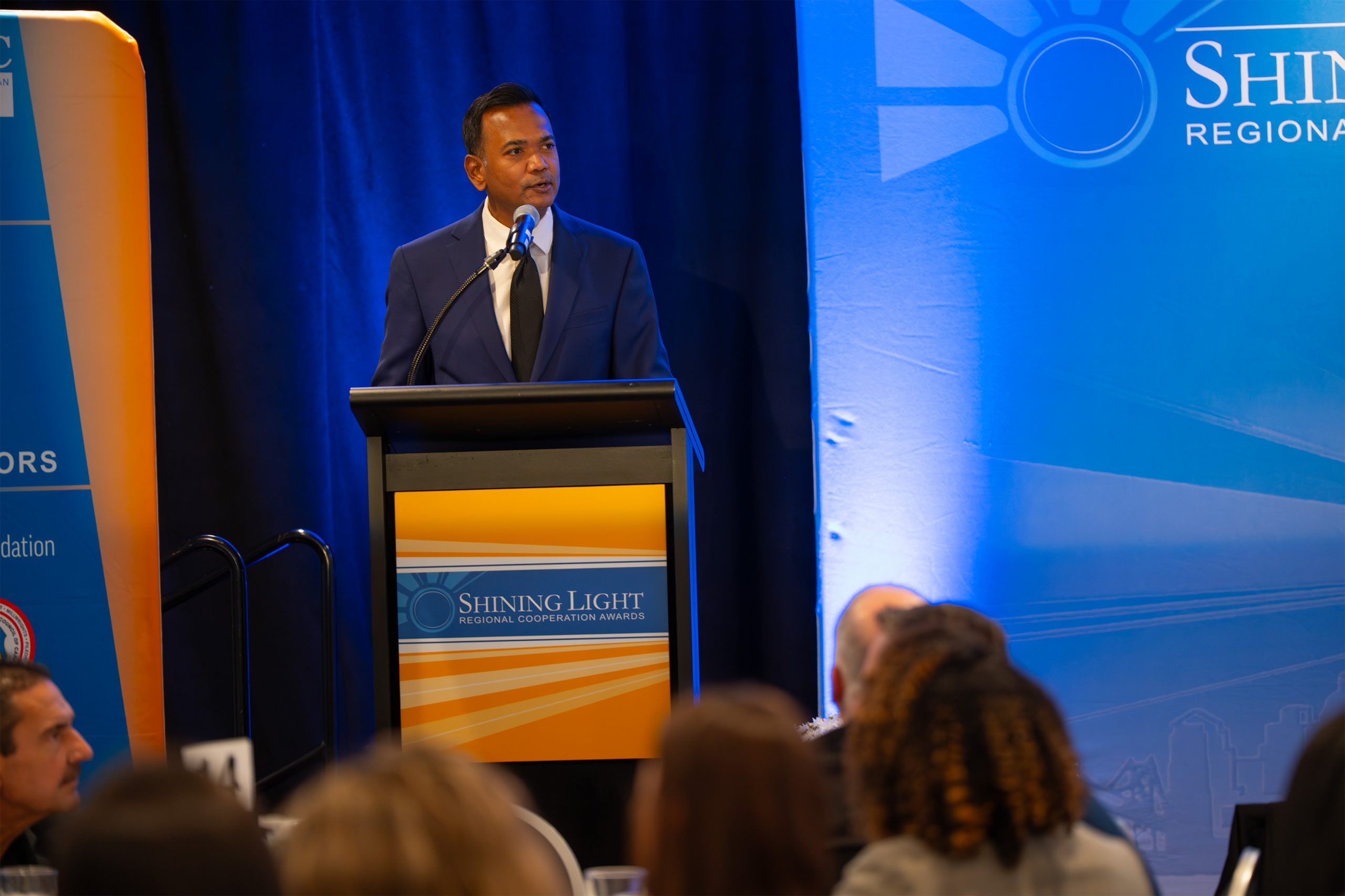 Images from the 2025 SEMCOG Shining Light Awards ceremony, showcasing honorees receiving recognition for outstanding regional cooperation and leadership. The photos feature award recipients posing with plaques, speakers addressing the audience, and attendees gathered in a formal event setting with branded banners and sponsor logos in the background.