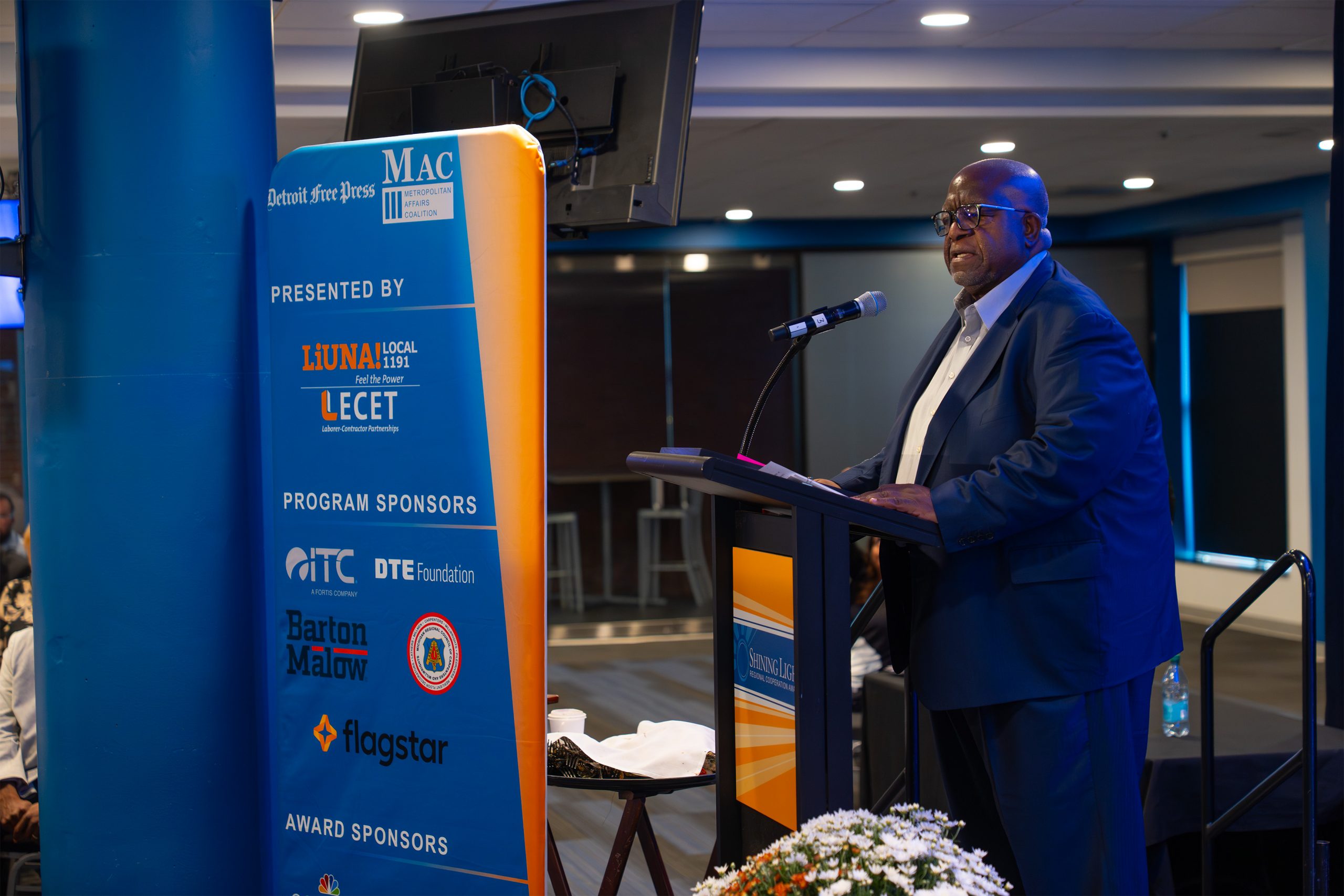 Outstanding African American man speaking at the Shining Light Awards ceremony, emphasizing recognition and celebration of community leaders, diversity, and excellence in leadership.