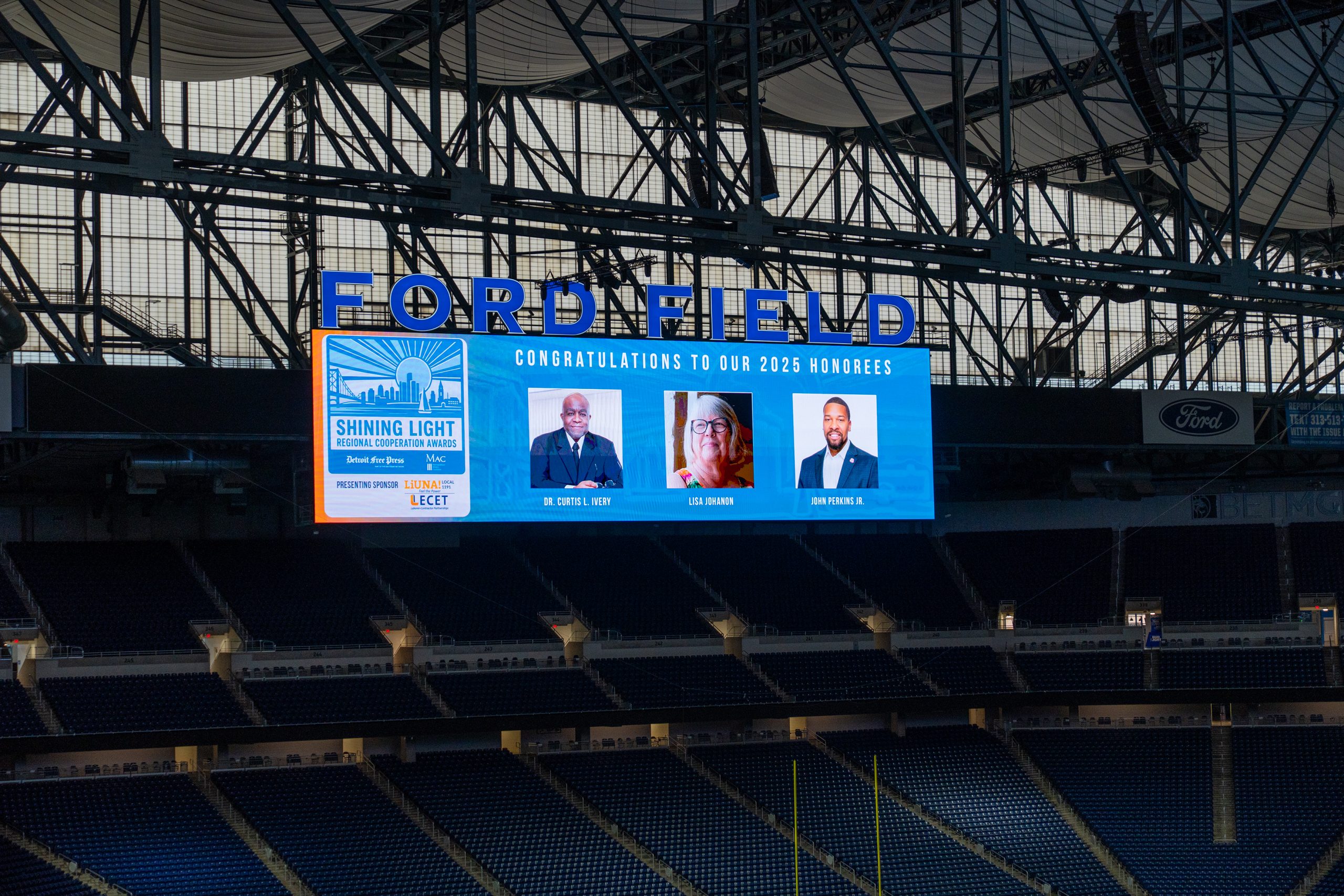 Ford Field interior during the Shining Light Regional Cooperation Awards, showcasing a digital screen honoring 2025 awardees, emphasizing community recognition and leadership.